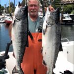 Harbor Port Commisioner Dennis Smith hoists a couple toads during the 2021 Santa Cruz salmon season.