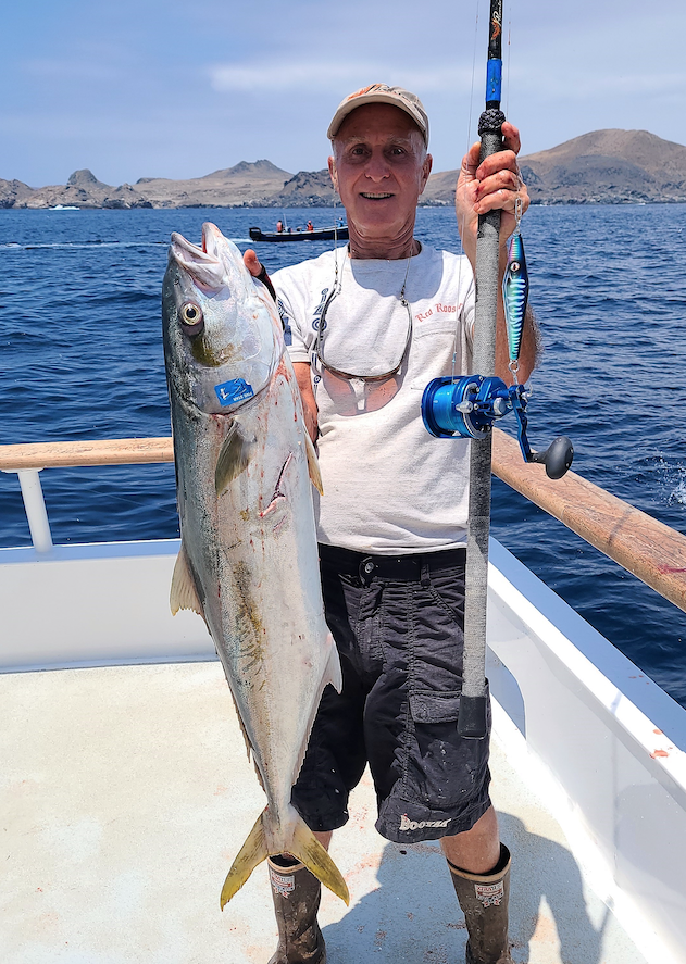 Deckhand readying small kite on short rod for fishing live bait