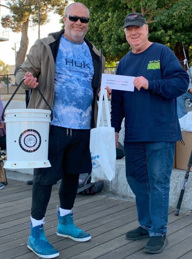 WON STAFFER BOB SEMERAU, right, hands out the cash and prizes for a 3rd place win to Paul Fanning, left, for his 12.14-pound ling.